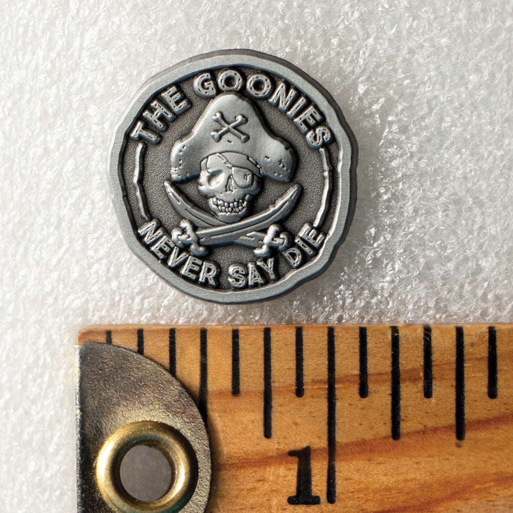 1 inch Goonies pirate coin enamel pin with One-Eyed Willie skull, collectible movie memorabilia pin shown with ruler for scale