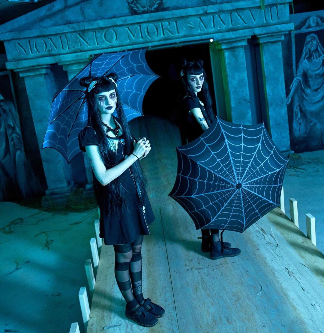 Spooky Gothic Twins holding the spider web umbrellas sold at nerd imports