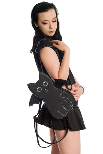 Goth woman wearing our convertible cat backpack as a shoulder bag.  Straps can be adjusted to wear as a backpack or crossbody bag.  The bat wings on the back of the cat are also removable.